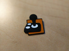 Load image into Gallery viewer, A black joystick with two white buttons on an orange background.
