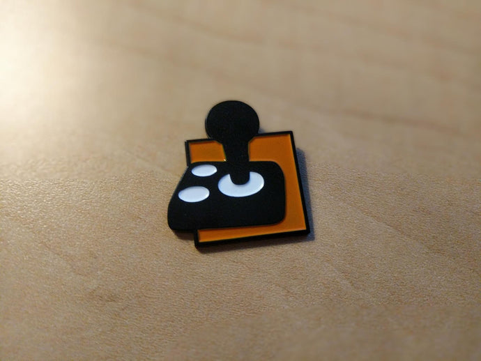 A black joystick with two white buttons on an orange background.