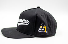 Load image into Gallery viewer, Black baseball cap w &quot;AbleGamers&quot; written in white. The writing is also raised so it has a puffy look. The AbleGamers logo, (am 80 Joystick with an Orange Square)  is on the side of the hat. 
