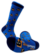 Load image into Gallery viewer, Med Blue socks with a dark blue heal, toe, and top. The AbleGamers logo, (Black joystick, white buttons, orange square behind it) tiled from top to bottom. this image has 2 socks in it. One sock is on its side showing the bottom with &quot;AbleGamers Charity&quot; and a large logo. 
